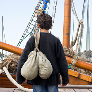 DALL·E 2022-10-26 19.48.28 - a ships apprentice boarding an old wooden ship with his sailors bag seen from behind